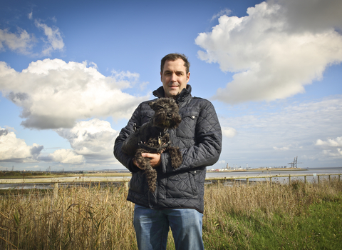 David holding his dog at a wetland